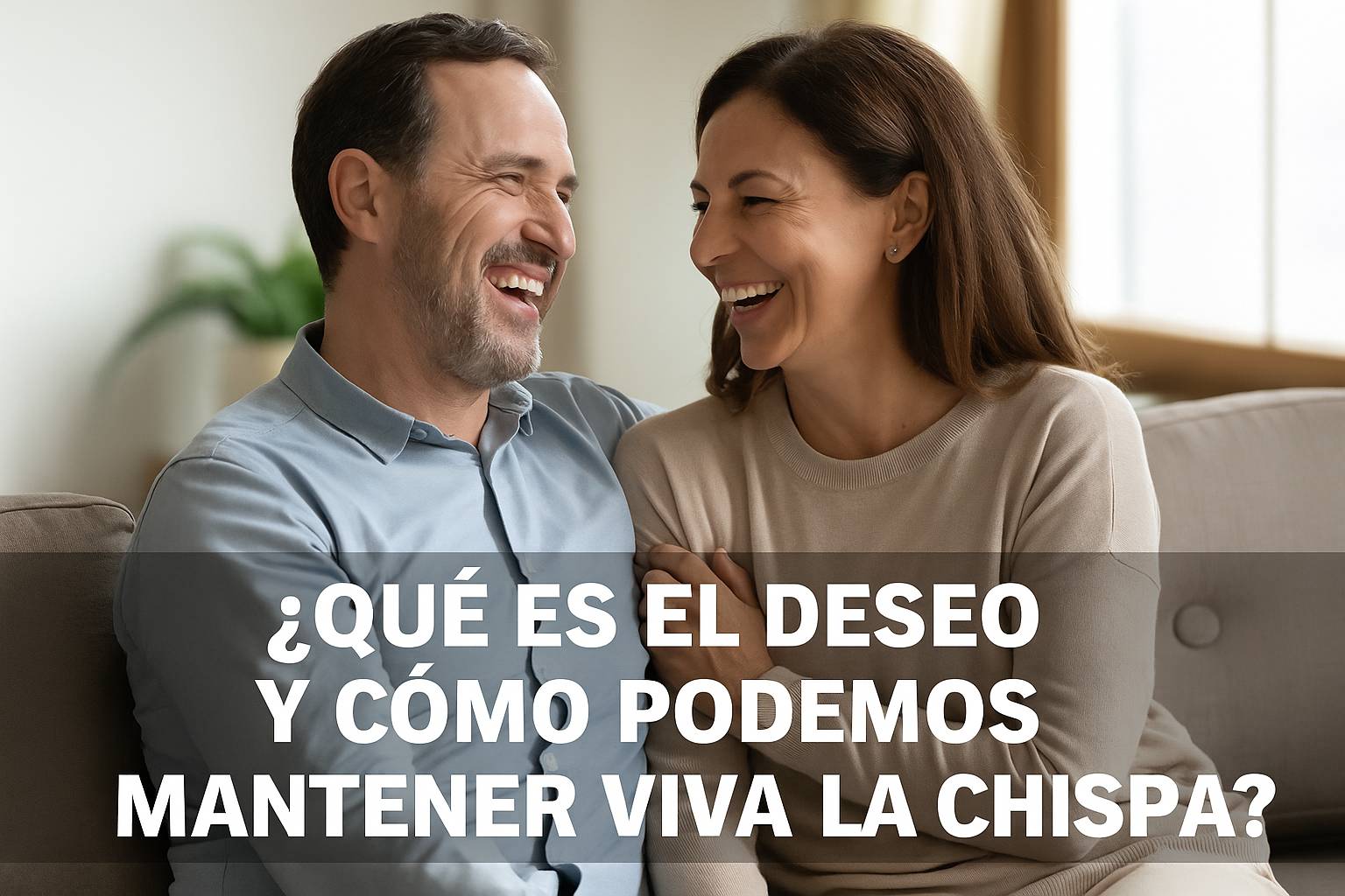 Pareja madura sonriendo y abrazándose en el sofá mientras se miran con complicidad. Imagen destacada para artículo sobre el deseo y cómo mantener la chispa viva en la relación.